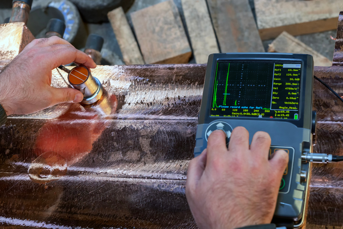 Technician performing nondestructive examination on a cast metal component.