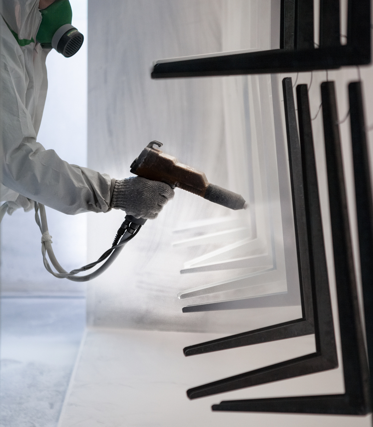 Metal components receiving an industrial coating on a controlled finishing line.