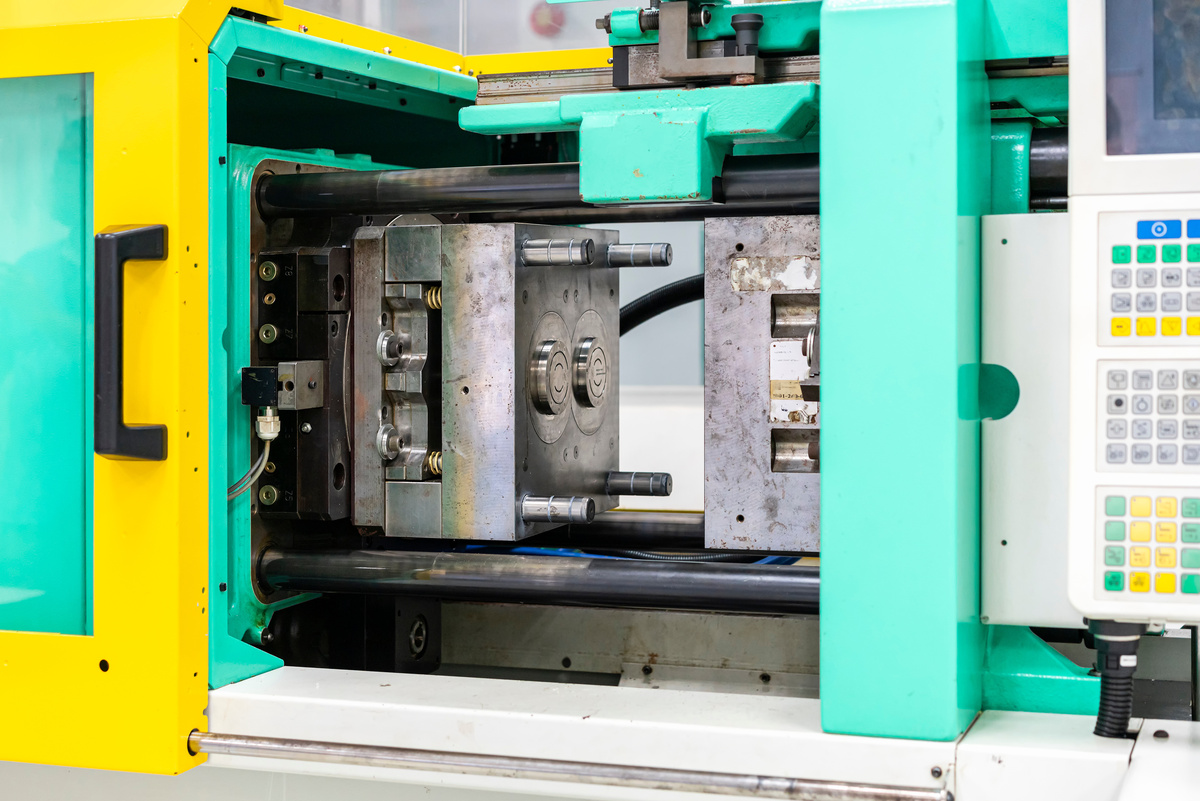 Injection mold producing a plastic component inside an industrial molding machine.