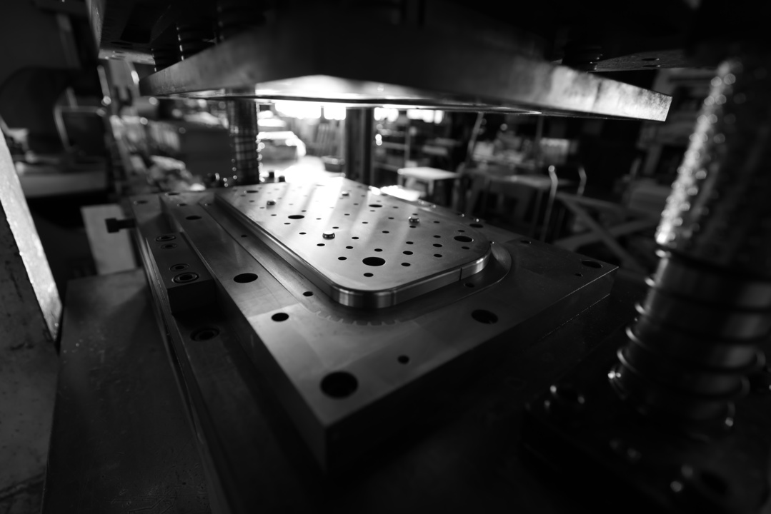 Coil-fed metal stamping press producing formed components through dedicated tooling.