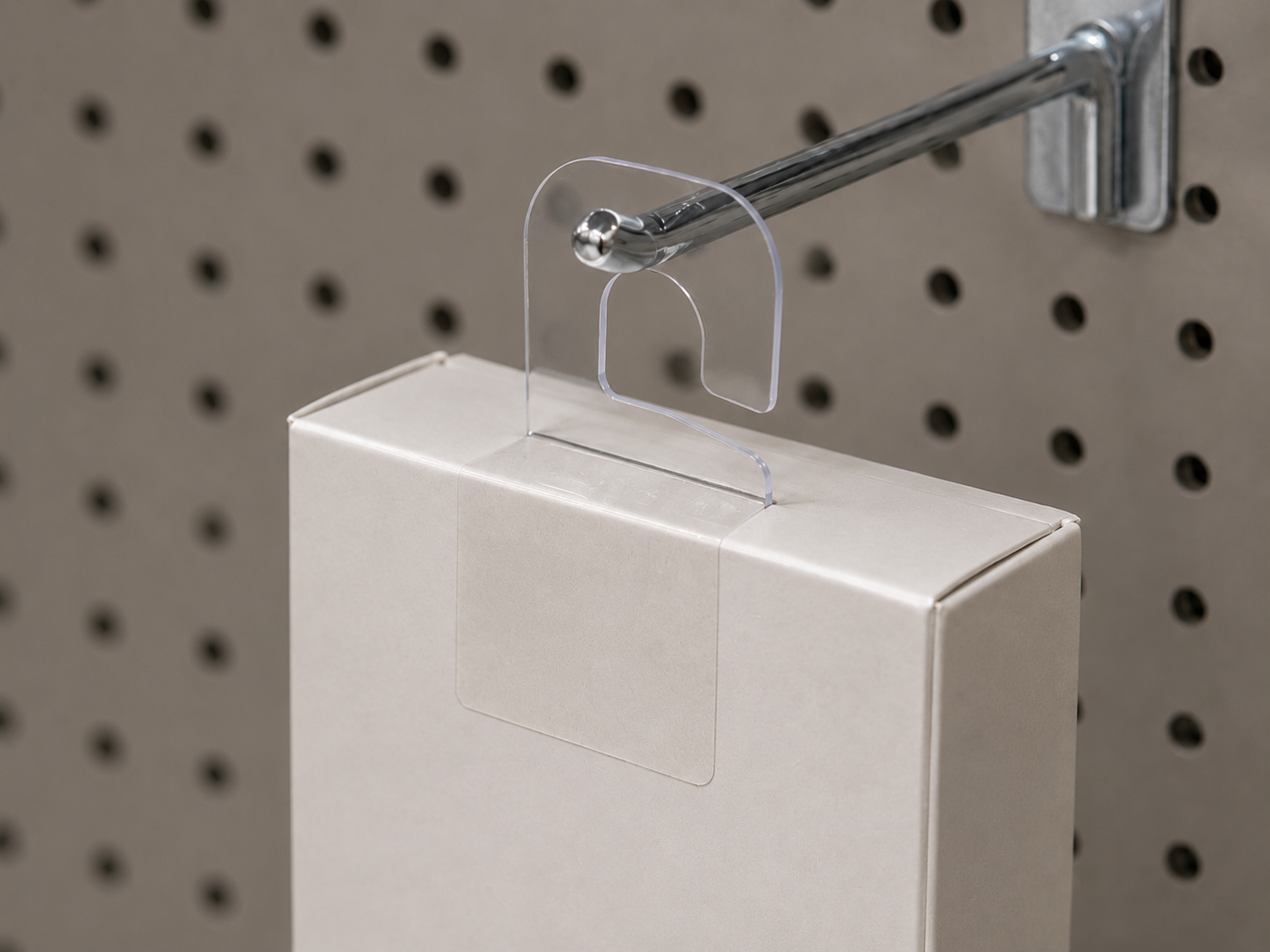 Plastic hardware components for packaging and retail display, including hang tabs and hooks on printed cartons.