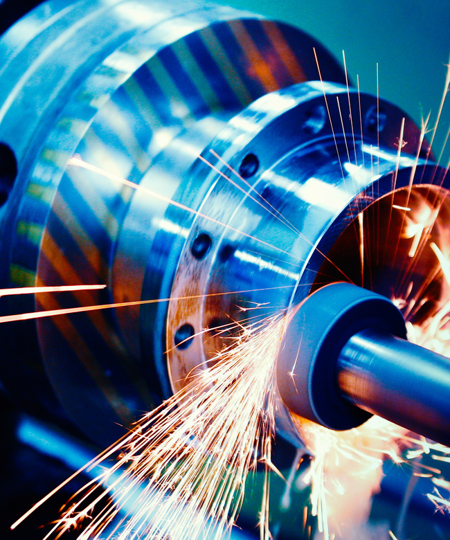 Close-up of a precision CNC laser cutting machine processing a metal sheet, with bright sparks flying as the cutting head creates high-precision components.
