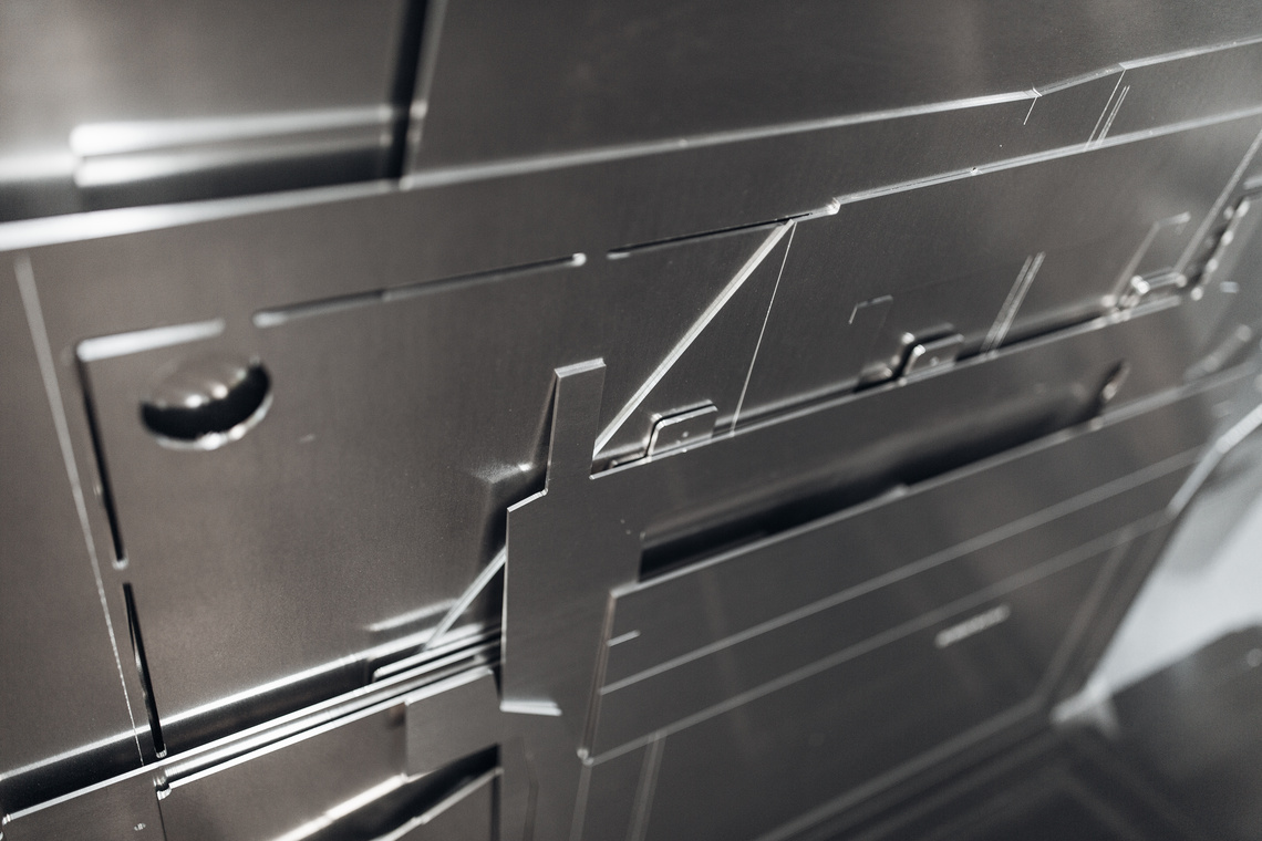 Flat sheet metal blanks and completed formed components showing the fabrication process